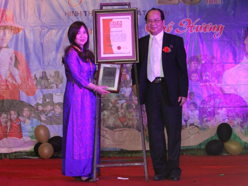 Bà Huỳnh Tiểu Hương đón nhận kỷ lục Châu Á “Người có sổ hộ khẩu dày và dài nhất  Châu Á” do GS –TS Hoàng Quang Thuận đại diện Tổ chức Kỷ lục Châu Á trao tặng