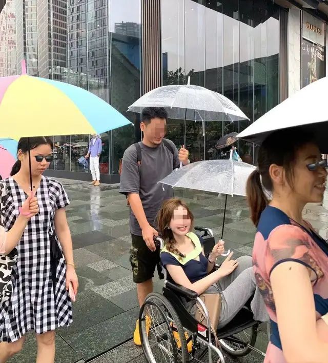 Ồn ào cảnh cô gái đi mua sắm bằng xe lăn chỉ để chân không dính mưa - Ảnh 1.
