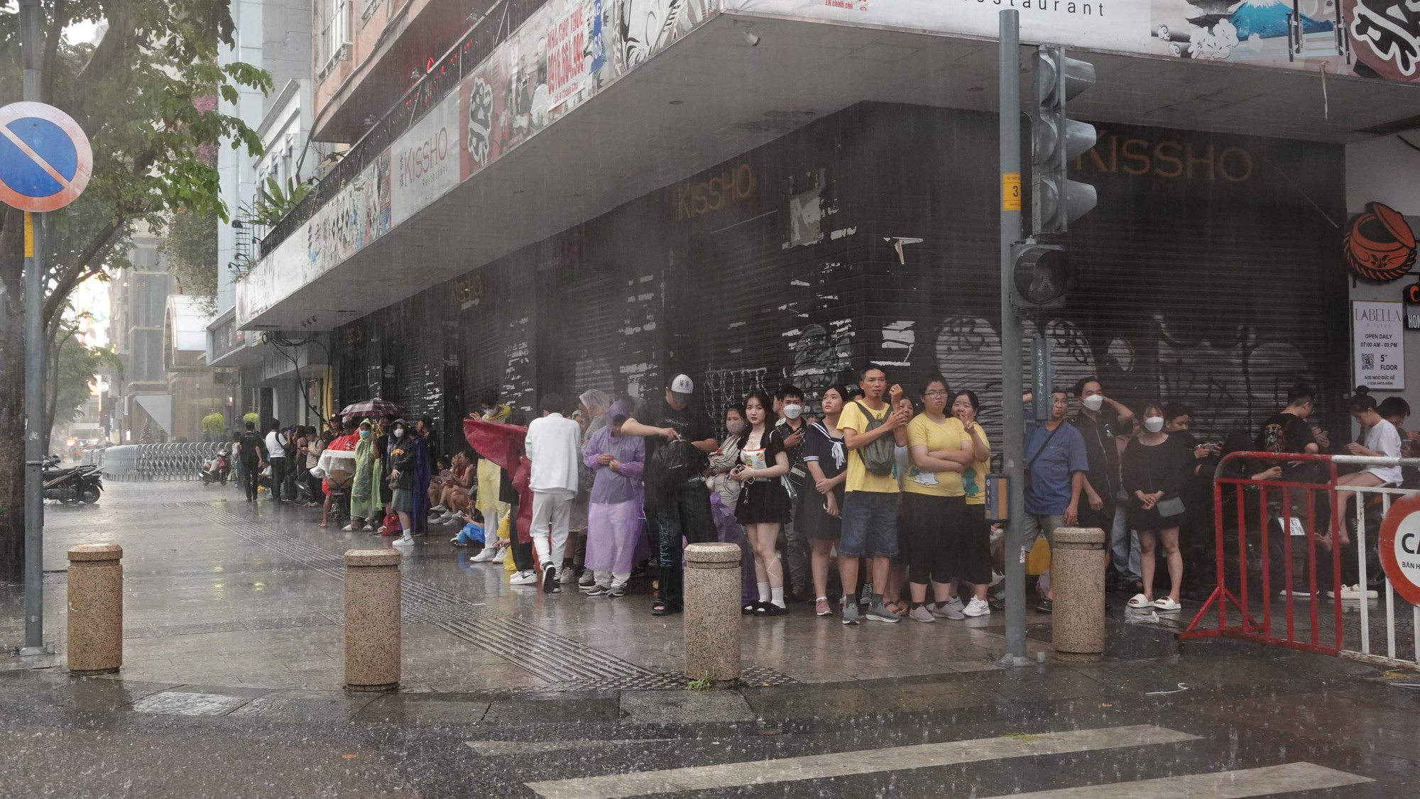 Nhiều người đi sớm giữ chỗ xem pháo hoa, hứng trọn cơn mưa ngay phố đi bộ Nguyễn Huệ chiều cuối năm- Ảnh 7.