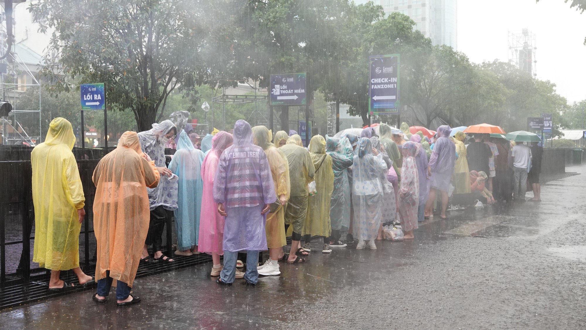 Nhiều người đi sớm giữ chỗ xem pháo hoa, hứng trọn cơn mưa ngay phố đi bộ Nguyễn Huệ chiều cuối năm- Ảnh 6.