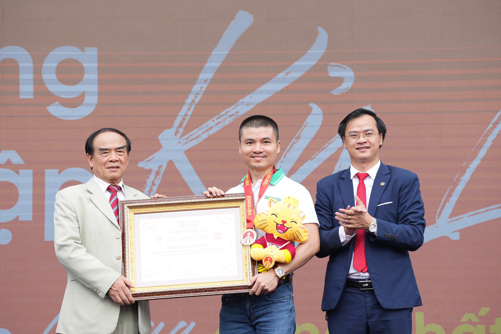 Tổng Biên tập báo điện tử Dân trí Phạm Tuấn Anh (giữa) nhận bằng xác nhận Kỷ lục Việt Nam