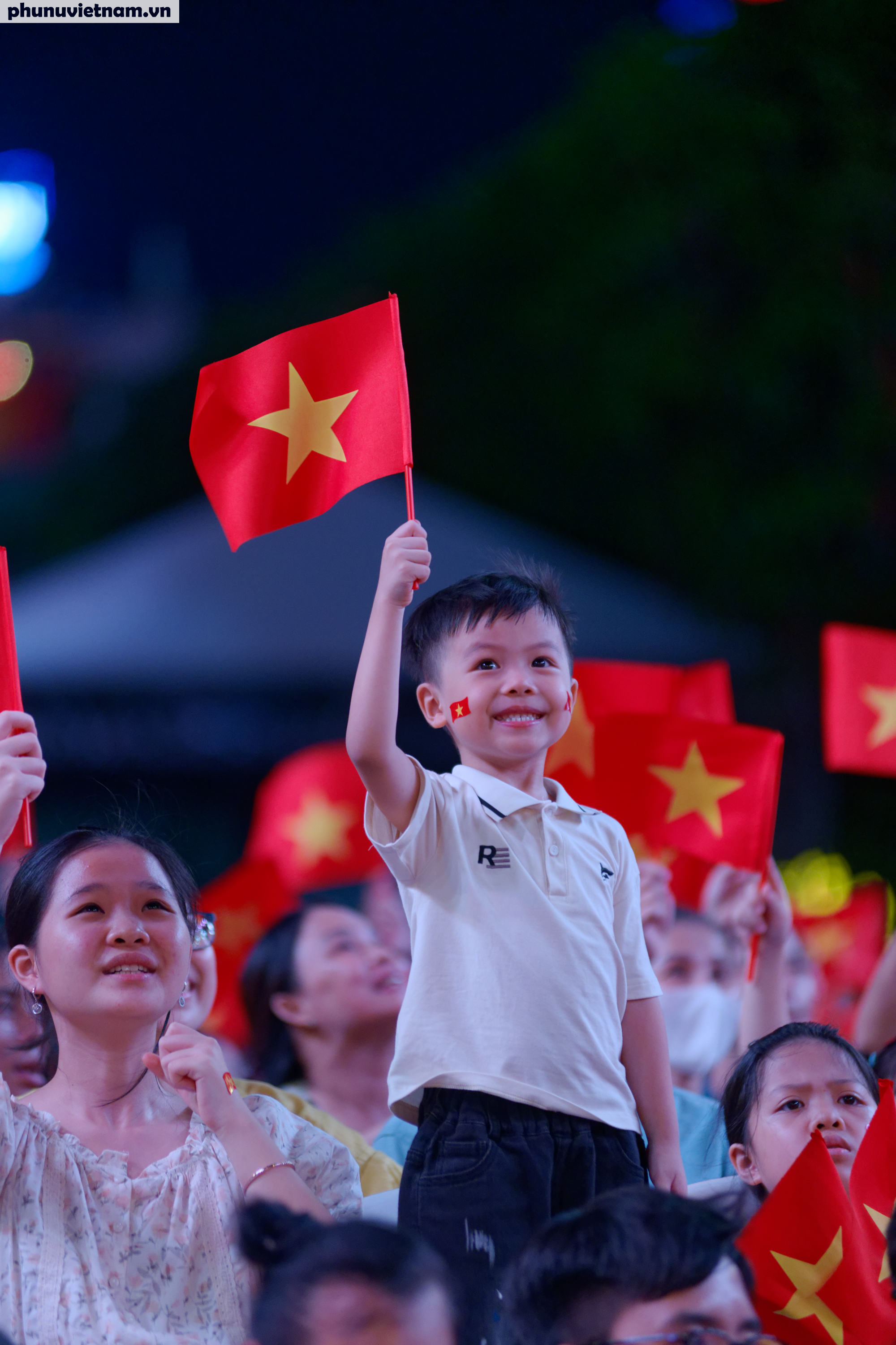 Em bé thích thú vẫy cờ khi những âm thanh hào hùng bắt đầu vang lên Em bé thích thú vẫy cờ khi những âm thanh hào hùng bắt đầu vang lên