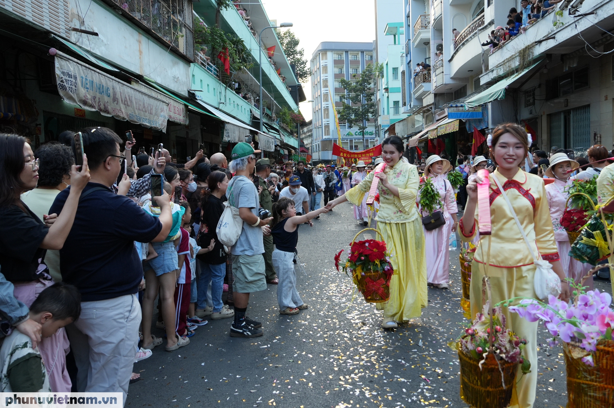 Các thiếu nữ trong trang phục truyền thống người Hoa được người dân  cổ vũ