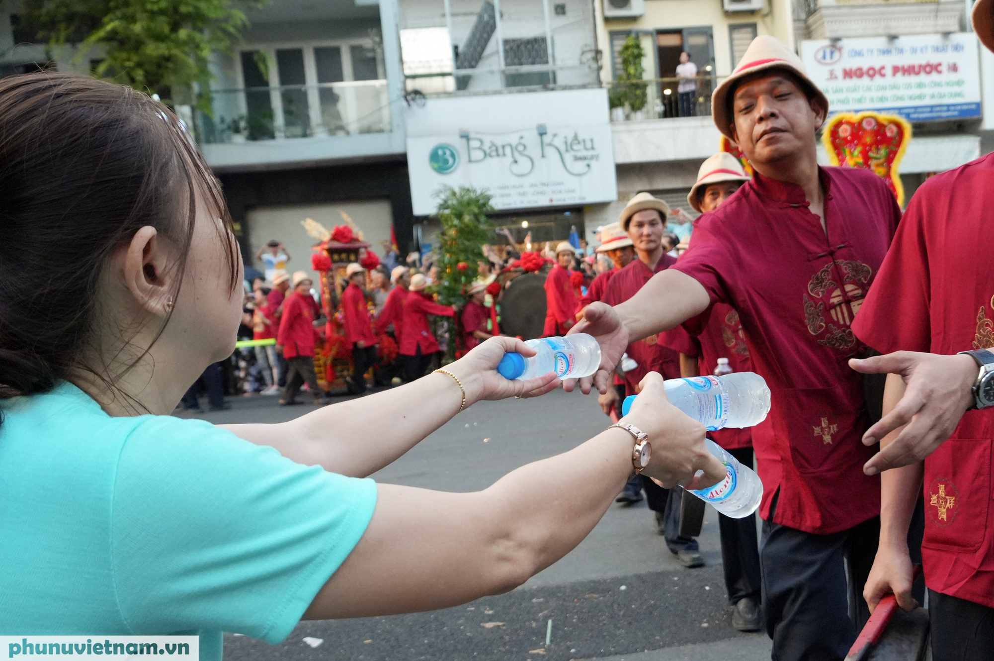 Người dân tiếp nước cho đoàn diễu hành
