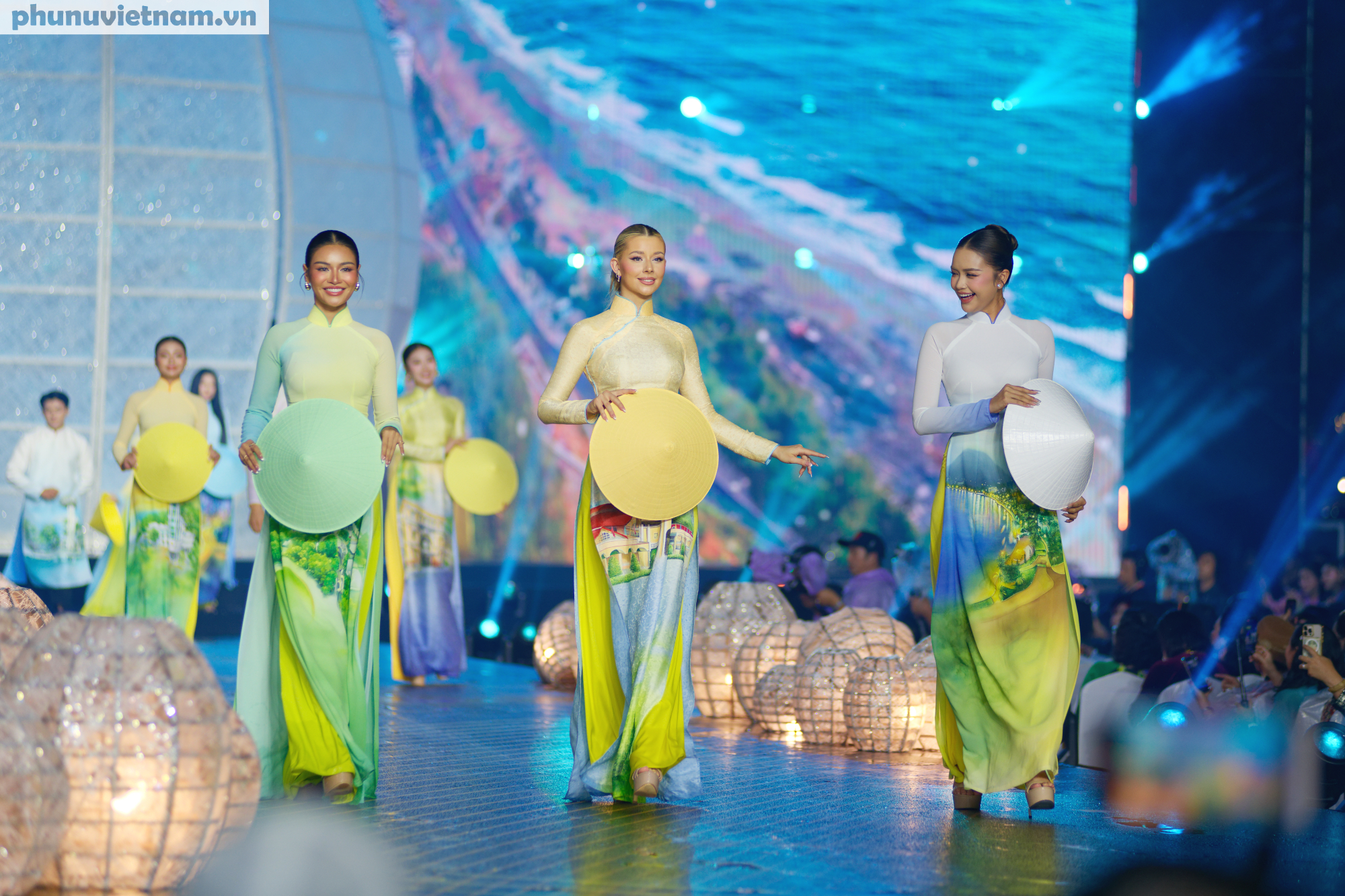 Hoa hậu Cosmo 2025 Yolina Lindquist - Đại sứ lễ hội  (giữa), Á hậu  Cosmo 2024 Mook Karnruethai Tassabut (trái)  và  -Hoa Hậu Hoàn Vũ Việt Nam 2022 Ngọc Châu  trong màn trình diễn bộ sưu tập áo dài  Thành Phố Vươn Mình” của Nghệ nhân - NTK Trung Đinh phần mở đầu đêm khai mạc