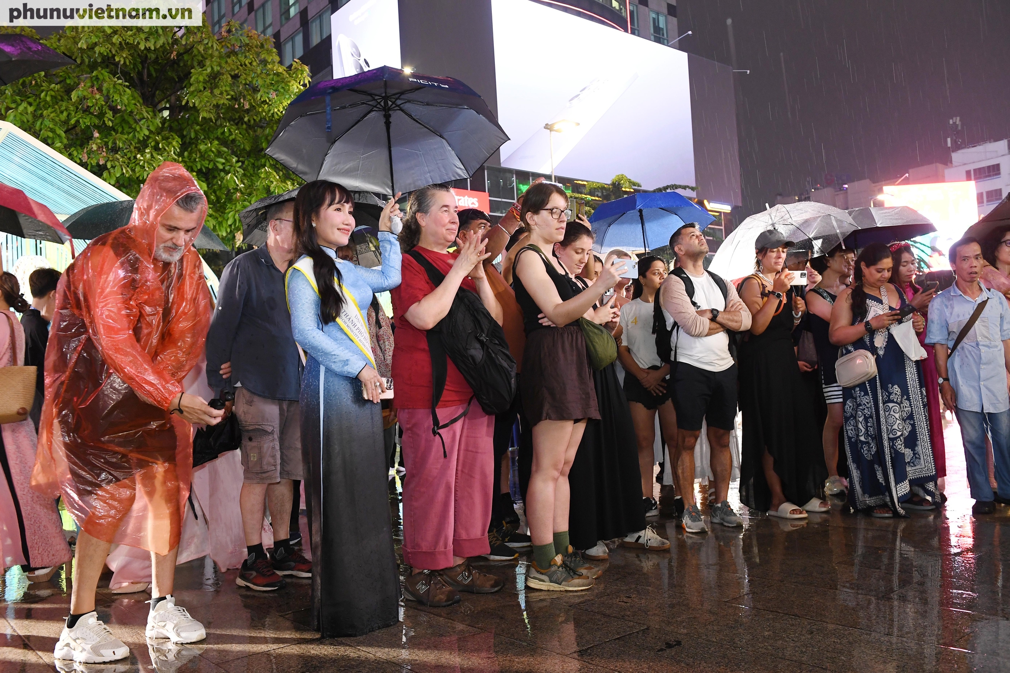 Bà Trịnh Thị Thanh hiện là Phó Chủ tịch Thường trực Hội Liên hiệp Phụ nữ  TPHCM (mặc áo dài bên trái) là đại sứ của Lễ hội áo dài TPHCM đang che dù cho du khách nước ngoài  xem tiết mục trình diễn tại buổi khai mạc