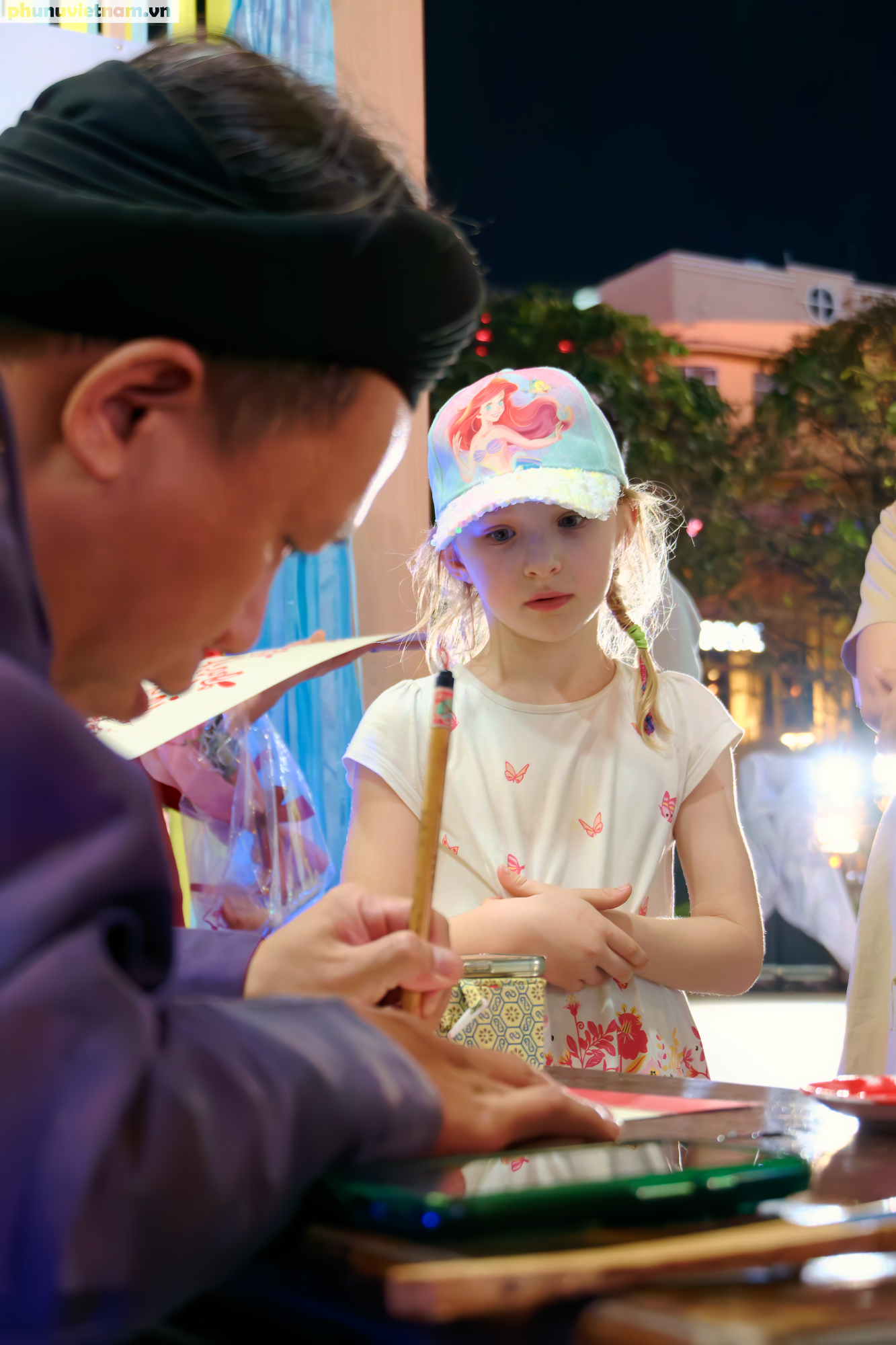 Em bé say mê xem ông đồ viết thư pháp