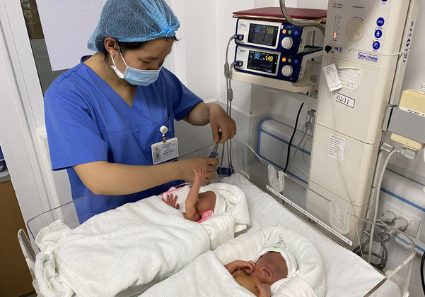 Cặp song sinh đầu tiên được chữa bệnh từ trong bào thai chào đời khỏe mạnh - Ảnh 1.