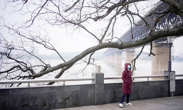 Một người phụ nữ đi bộ dưới cầu bên sông Dương Tử ở Vũ Hán