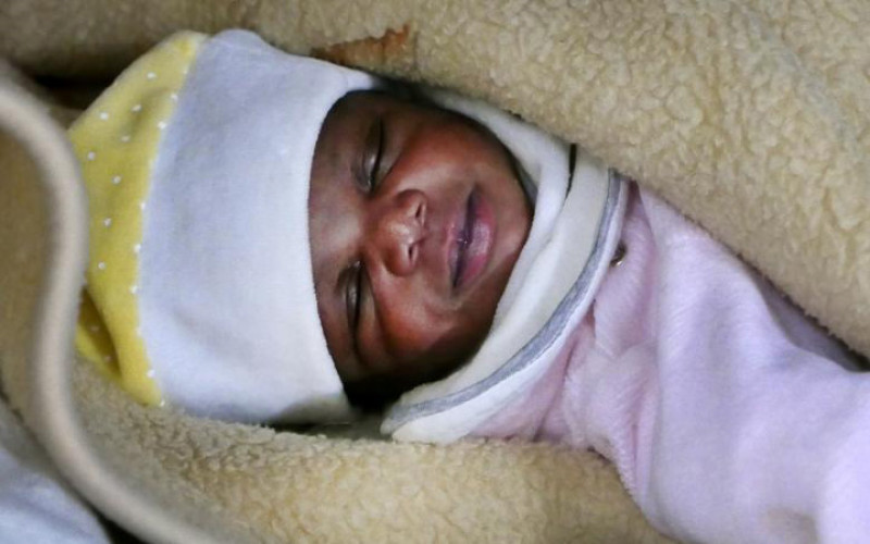 Một bé gái sơ sinh ngủ ngon lành sau khi được cứu từ một chiếc thuyền cao su chở đầy người di cư. Cô bé là 1 trong số 480 người được tổ chức phi chính phủ của Tây Ban Nha có tên 