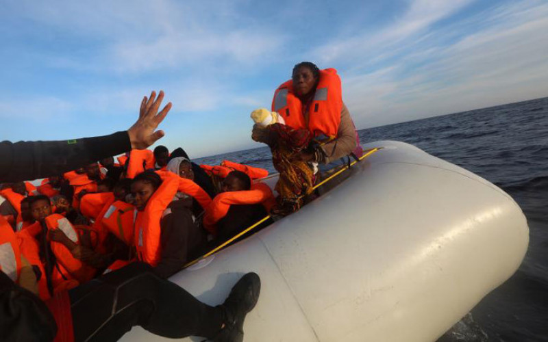 Em bé 4 ngày tuổi này cùng với hàng trăm người di cư khác từ Bắc và Trung Phi vượt Địa Trung Hải tới châu Âu. Họ được phát hiện đang lênh đênh trên thuyền cao su cách thị trấn Sabratha của Libya 22 hải lý.