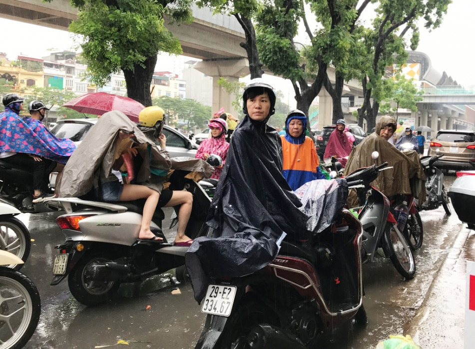 Tại điểm thi THPT Quang Trung (Q.Đống Đa, Hà Nội), giao thông ùn tắc khi cơn mưa to như trút nước bất ngờ ập xuống, gây trở ngại cho phụ huynh đi đón con sau giờ thi KHXH