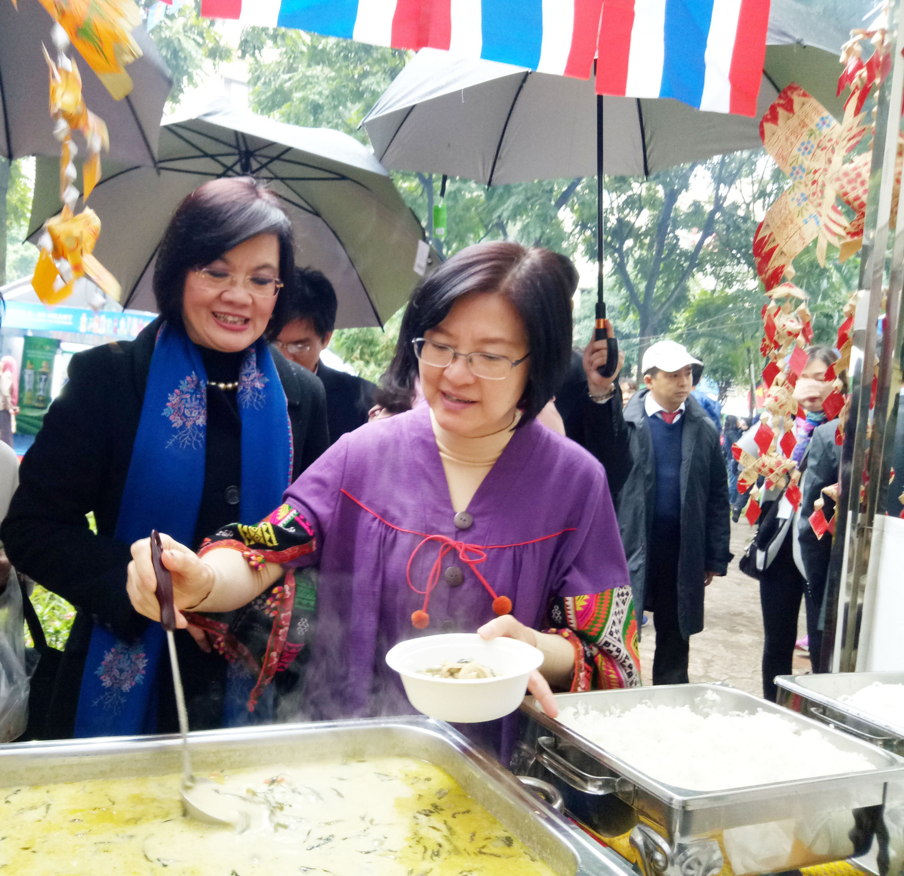 Bà Wanthanee Viputwongsakul - Đại biện lâm thời Đại sứ quán Thái Lan tại Hà Nội lấy thức ăn mời Đại sứ Nguyễn Nguyệt Nga thưởng thức ẩm thực Thái Lan.