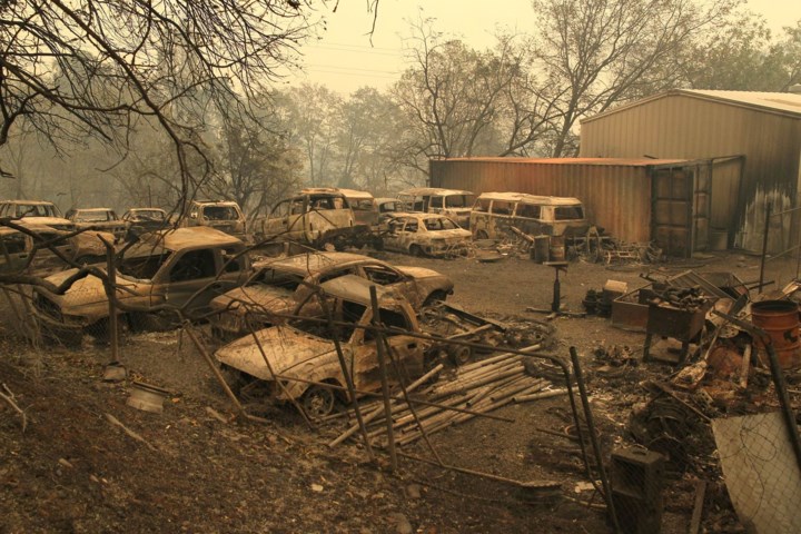 Những chiếc ô tô bị phá hủy nặng nề với những lớp tro dày phủ bên trên nằm giữa một vùng tan hoang, xơ xác. Ảnh: USA Today