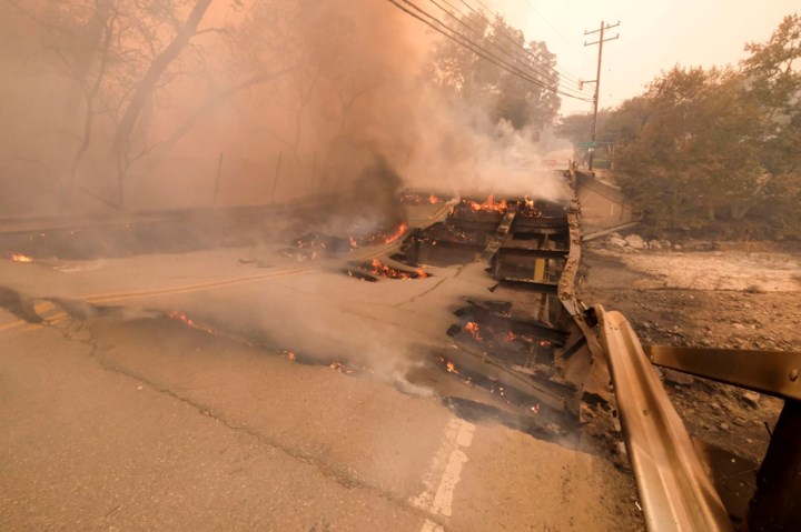 Đám cháy Woolsey lan rộng và phá hủy cả một cây cầu trên quốc lộ  Mulholland, gần đường Kanan ở Malibu. Ảnh: AP