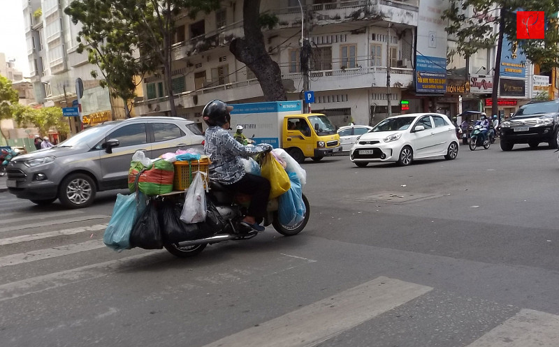 Người phụ nữ này vừa ra khỏi chợ An Đông với số lượng lớn thực phẩm mua về cho quán ăn của mình được gắn kín bề mặt xe 