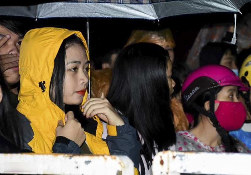 Trong khi thời tiết ở Hà Nội (20 độ C) và Sài Gòn (28 độ C), thuận lợi cho các hoạt động ngoài trời thì các địa phương miền Trung như thành phố Vinh, Đà Nẵng, Huế... lại mưa, lạnh. Ảnh chụp tại Đà Nẵng trong không khí mưa nhẹ, người dân nơi đây đội mưa chờ năm mới. Nguồn: Zing