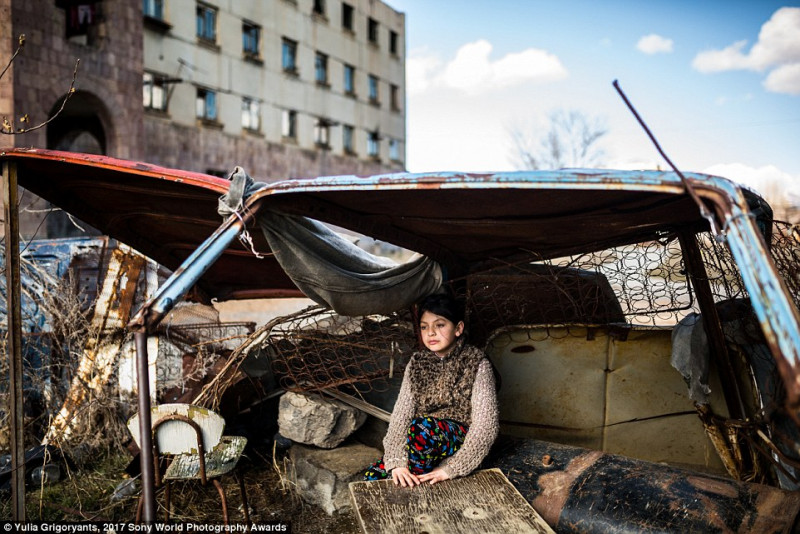 Syuzanna, 9 tuổi, trú tạm sau xe ô tô bị bỏ lại bên ngoài một tòa nhà bỏ hoang ở Gymri, Armenia, nơi mà tỷ lệ đói nghèo lên tới 47%.