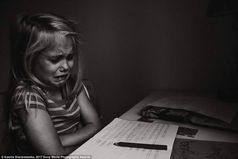 Nhiếp ảnh gia Kamila Staniszewska, người Ba Lan, đã bắt được hình ảnh cô con gái 6 tuổi của mình khóc hết nước mắt trước bài tập về nhà.