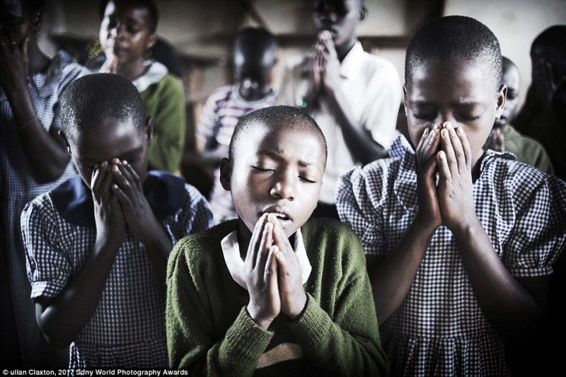 Những cô bé chắp tay cầu nguyện tại một trường học ở vùng nông thôn phía tây nam Uganda, vào buổi sáng sớm, trước khi lớp học bắt đầu.
