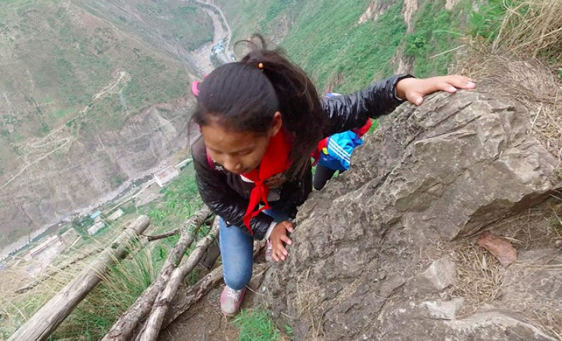 Một bé gái đang leo lên ngọn núi.