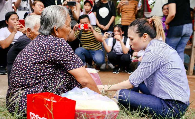 Hình ảnh nữ ca sĩ ngồi bệt xuống vệ đường để trò chuyện cùng những cụ già đang chờ người nhà đón bên lề đường làm nhiều người không khỏi xúc động.