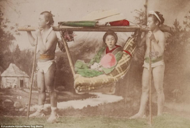 Một người phụ nữ được hai người đàn ông khiêng trên chiếc kago – phương tiện vận chuyển chuyên dụng cho người giàu tại Nhật.