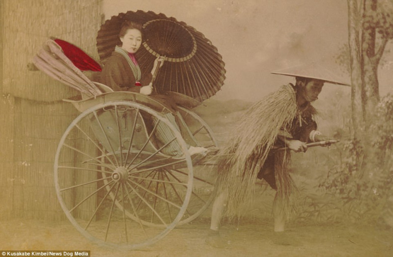 Một người phụ nữ cầm chiếc dù trên xe kéo – phương tiện vận chuyển được phát minh tại Nhật Bản vào khoảng năm 1869. Đến năm 1872, xe kéo trở thành phương tiện giao thông chính trong nước, với khoảng 40.000 người kéo xe. Tuy nhiên, đến năm 1930, con số này bắt đầu giảm do có nhiều phương tiện tân tiến khác thay thế. Thế nhưng, từ những năm 70 trở lại đây chiếc xe kéo lại được tái hiện để thu hút khách du lịch.