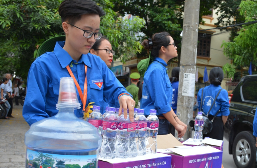 Lực lượng sinh viên tình nguyện có mặt đông đảo, phục vụ nước uống, bánh và quạt miễn phí cho thí sinh và người nhà