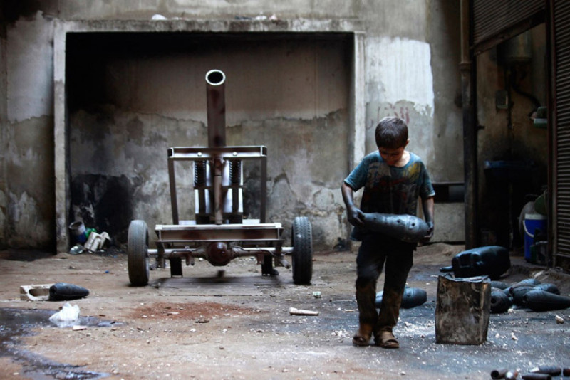 Bé Issa, 10 tuổi đang làm việc ở nhà máy vũ khí tại Aleppo, Syria.