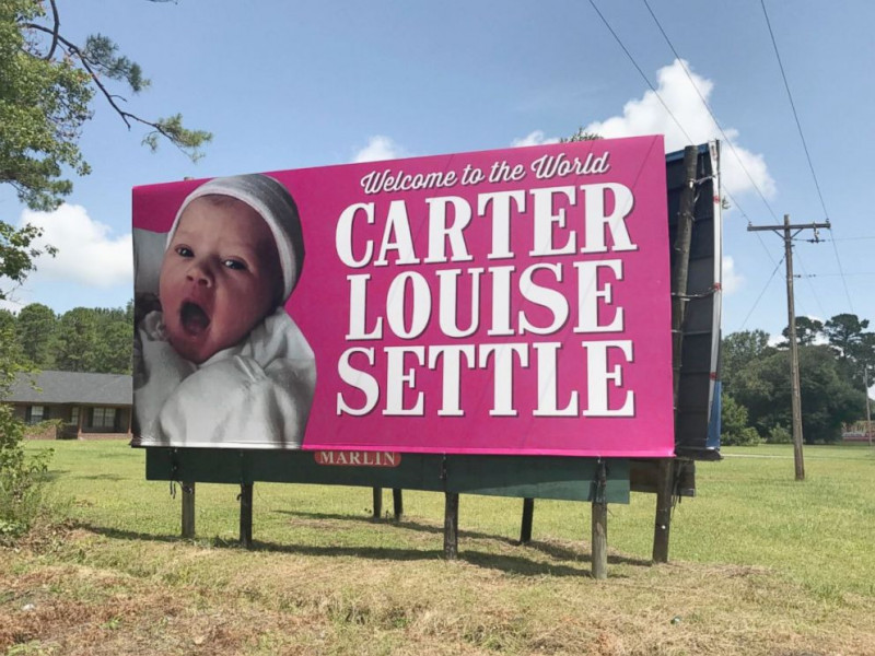 Will Settle hiện là giám đốc một công ty thi công quảng cáo ngoài trời. Nhờ sự giúp sức từ các đồng nghiệp của Will, bé gái mới chào đời đã được trưng biển quảng cáo cỡ lớn (cao 3,6m và rộng 7,3m) tại một vị trí bắt mắt ngay trên cao tốc South Carolina ở khu vực giữa Bluffton và Savannah với dòng chữ: Chào mừng đến với thế giới này, Carter Louise Settle!
