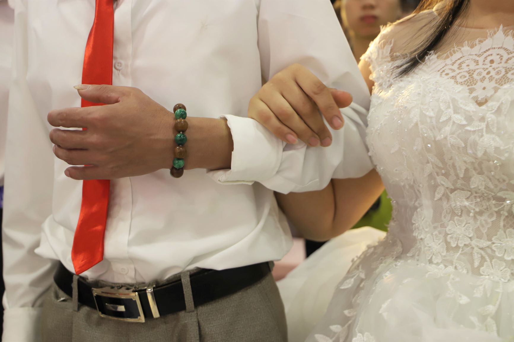 Hình ảnh ấm áp của một cặp đôi khi cô dâu khoác tay chú rể đầy tình cảm trong giờ phút thiêng liêng.