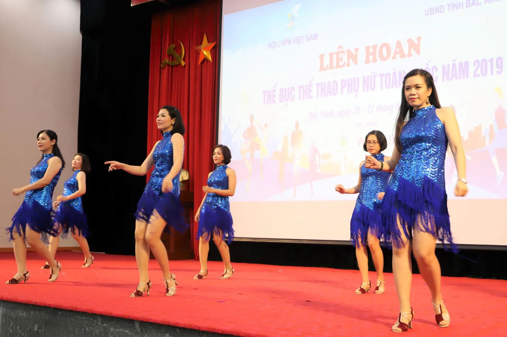 Lựa chọn tông váy màu xanh với thiết kế đầu nữ tính, thướt tha, các nữ vận động viên của Hội LHPN Việt Nam mang đến hai tiết mục nhảy dance sport vừa nhẹ nhàng uyển chuyển nhưng không kém phần năng động