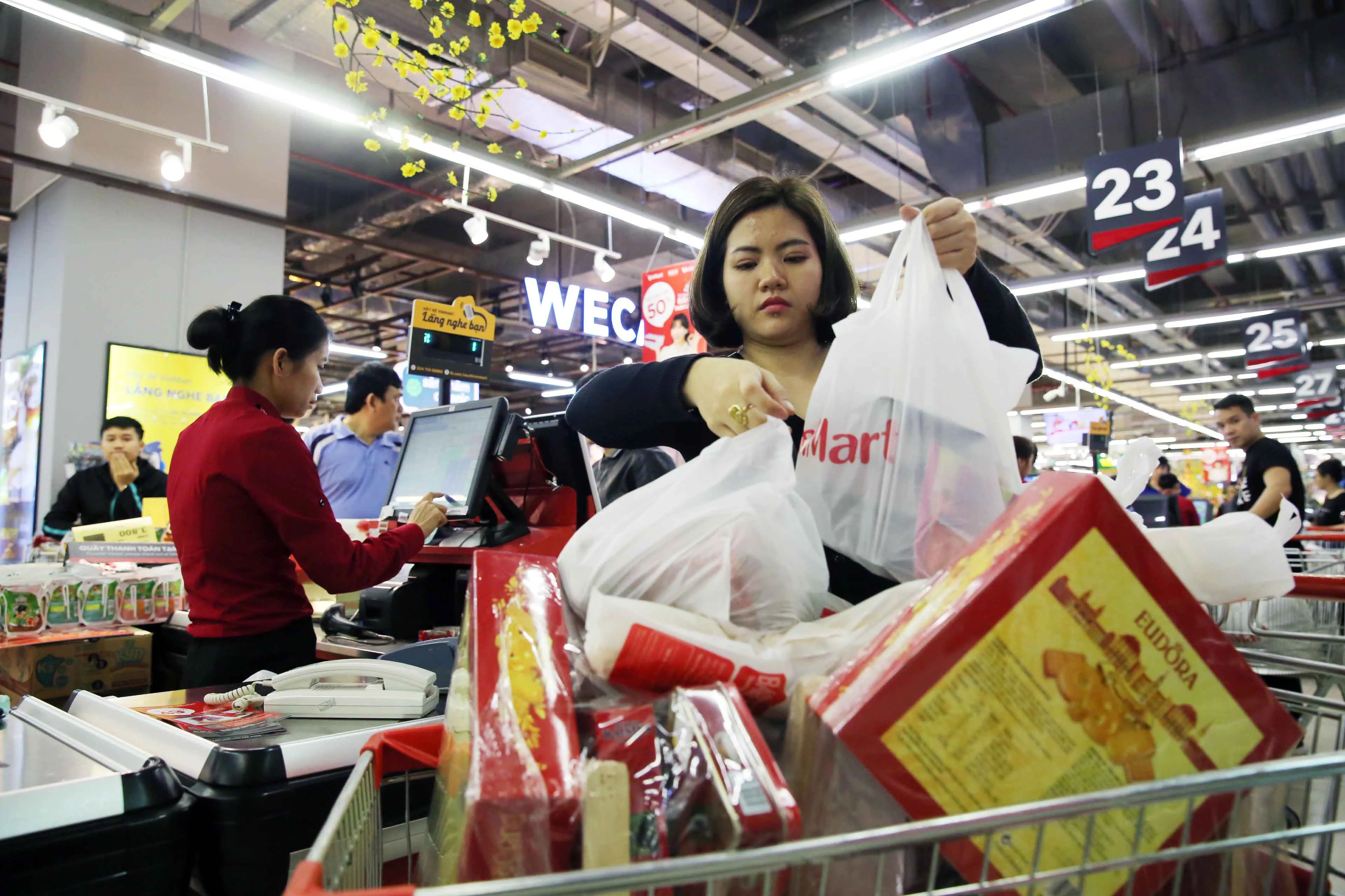 Chỉ còn 1 ngày nữa là đến thời khắc chuyển giao giữa năm mới và năm cũ, thời điểm này, người dân Hà Nội đang cấp tập đi mua sắm Tết. Ảnh chụp một người phụ nữ với xe đẩy hàng đầy ắp tại siêu thị VinMart Times City (Hà Nội).
