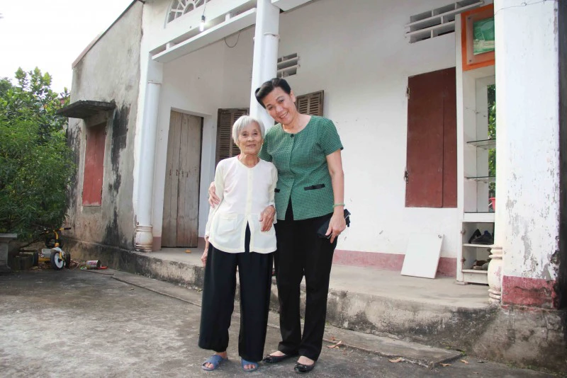 Phó Chủ tịch Hội LHPNVN Nguyễn Thị Tuyết chụp ảnh cùng nữ cựu dân quân trước ngôi nhà đơn sơ, còn nhiều gian khó của bà Nguyễn Thị Tình, nguyên Trung đội trưởng pháo phòng không Lam Hạ