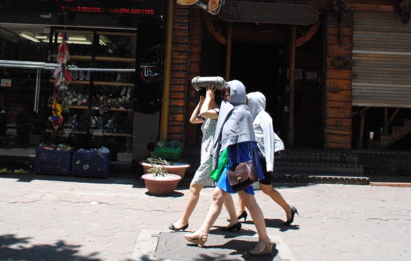 Không khó để bắt gặp hình ảnh các chị em phụ nữ trùm kín người di chuyển vội vã dưới trời nắng nóng như thiêu đốt.
