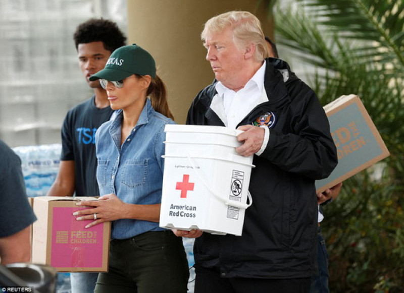 Ông bà Trump giúp chuyển các thùng hàng lên xe tải bên ngoài một trung tâm cứu trợ. Số hàng này sẽ được đưa tới những người bị bão ảnh hưởng ở thành phố Houston.
