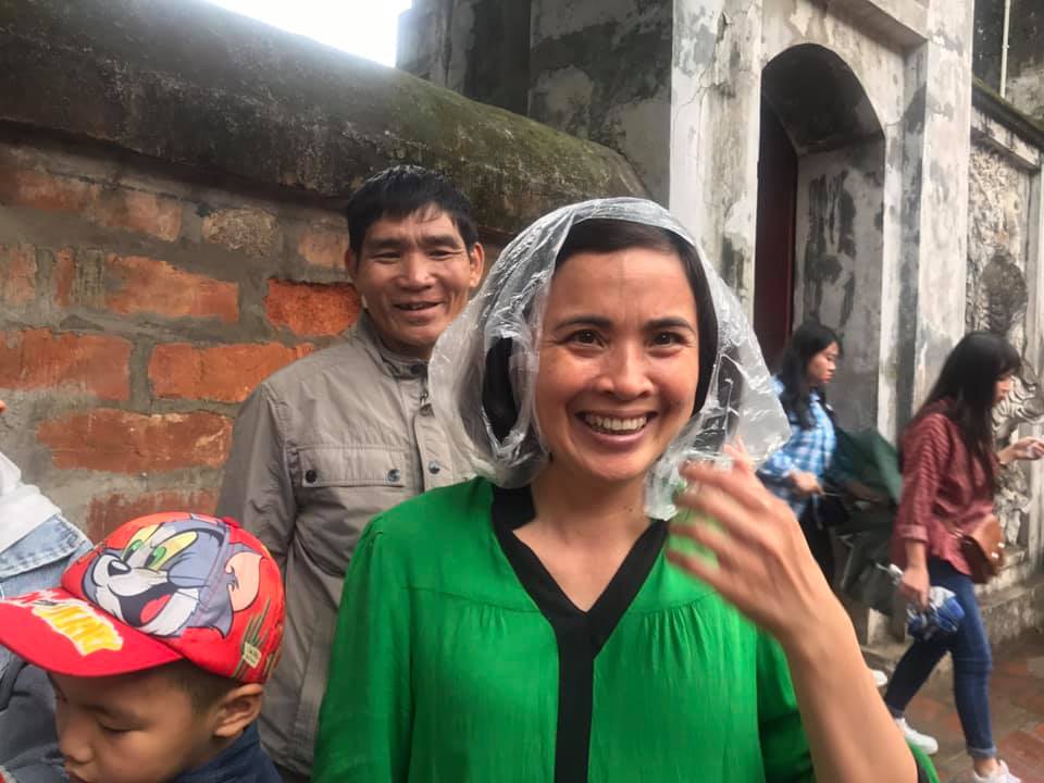 Người phụ nữ từ Bắc Giang dùng cả túi nilon đội lên đầu cho khỏi ướt khi vào Văn Miếu. 