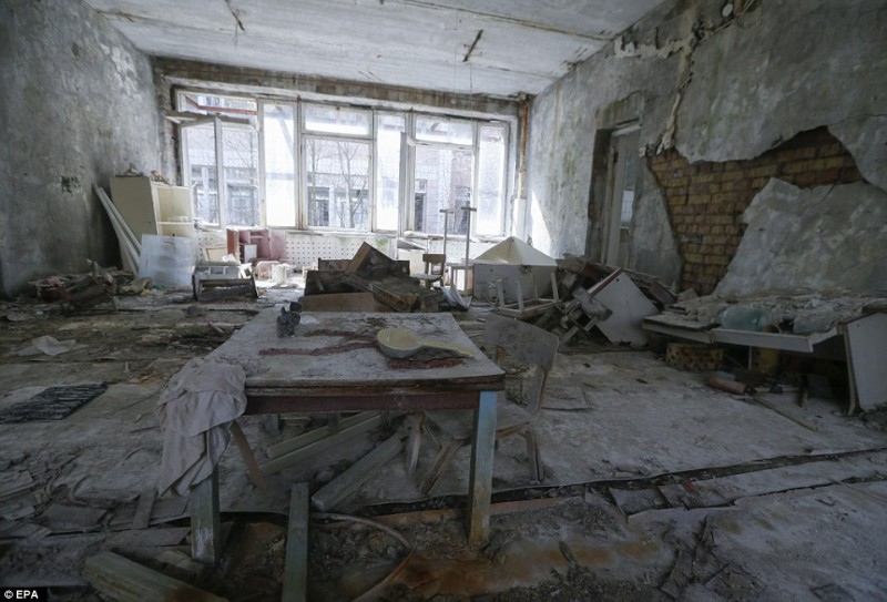 Căn phòng trong một trường mẫu giáo ở thị trấn Pripyat bị bỏ hoang. Đồ dùng chất ngổn ngang, bức tường nứt vỡ rơi xuống mang đầy vẻ hoang tàn.