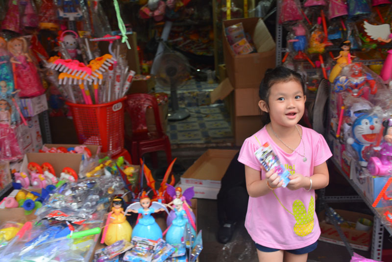 Một em bé tỏ ra thích thú được bố đưa đi lựa lồng đèn, đồ chơi trên phố lồng đèn Lương Nhữ Học.
