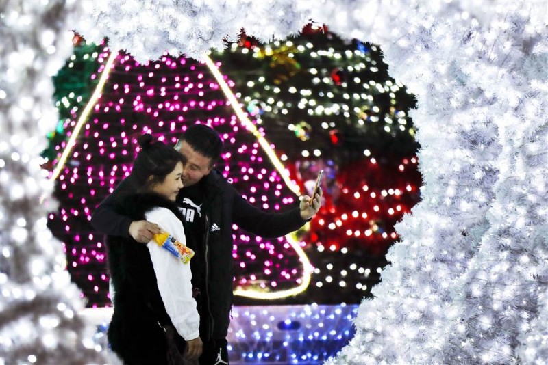 Tại Trung Quốc, một người đàn ông đã ôm người thân của mình và chụp hình bên một tòa văn phòng được trang trí Noel rất ấm cúng hôm 1/12. Mặc dù Giáng sinh không phải là truyền thống của đất nước này, song một số tòa nhà văn phòng và trung tâm mua sắm đều chào mừng ngày lễ này.
