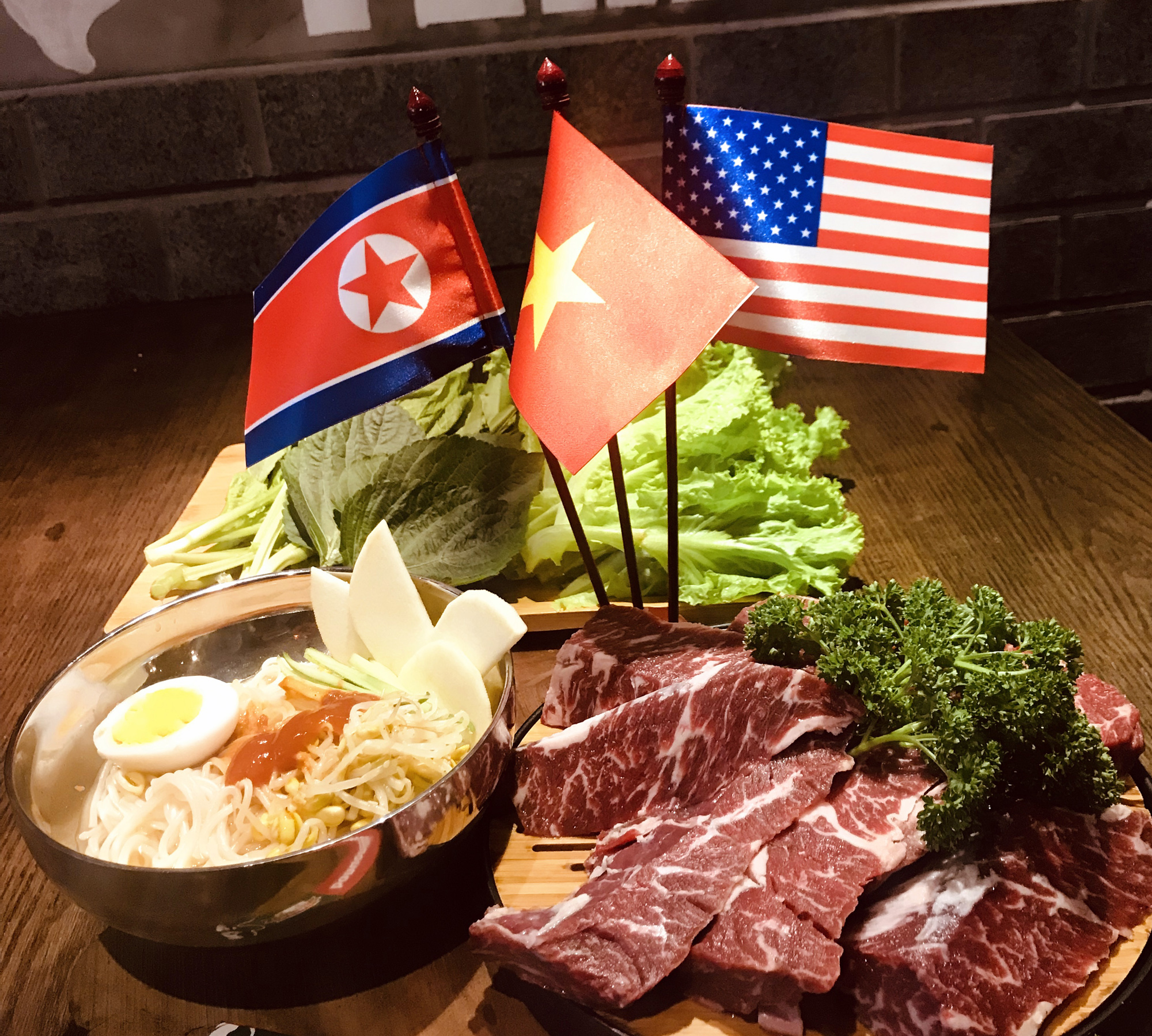 Dành tình yêu cho đất nước Triều Tiên sau chuyến thăm mới đây tới đất nước này, anh Trương Quốc Hùng, chủ 1 nhà hàng tại phố Tô Hiến Thành (Hà Nội), đã quyết định đưa món mì lạnh Triều Tiên vào thực đơn của nhà hàng. Những lá cờ Mỹ, Triều Tiên và Việt Nam đã được xuất hiện cùng các món ăn.