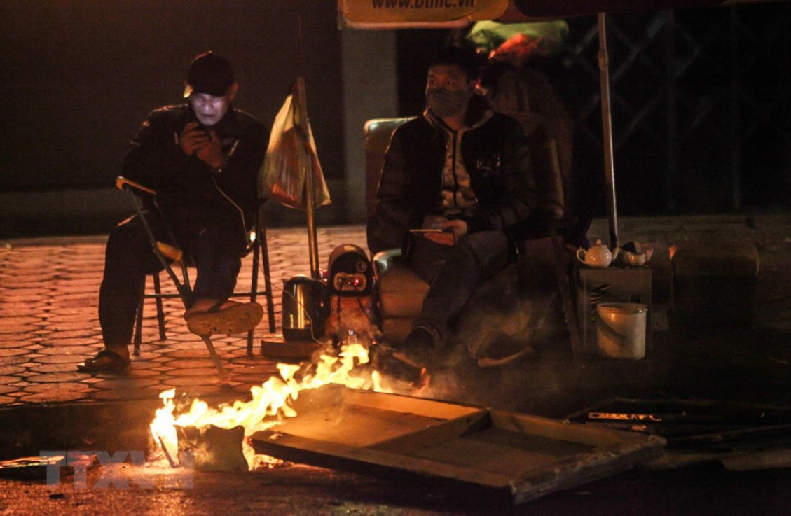 Người dân lao động đốt lửa, chống lại cái lạnh trong đêm 28/12 trên phố Hào Nam.