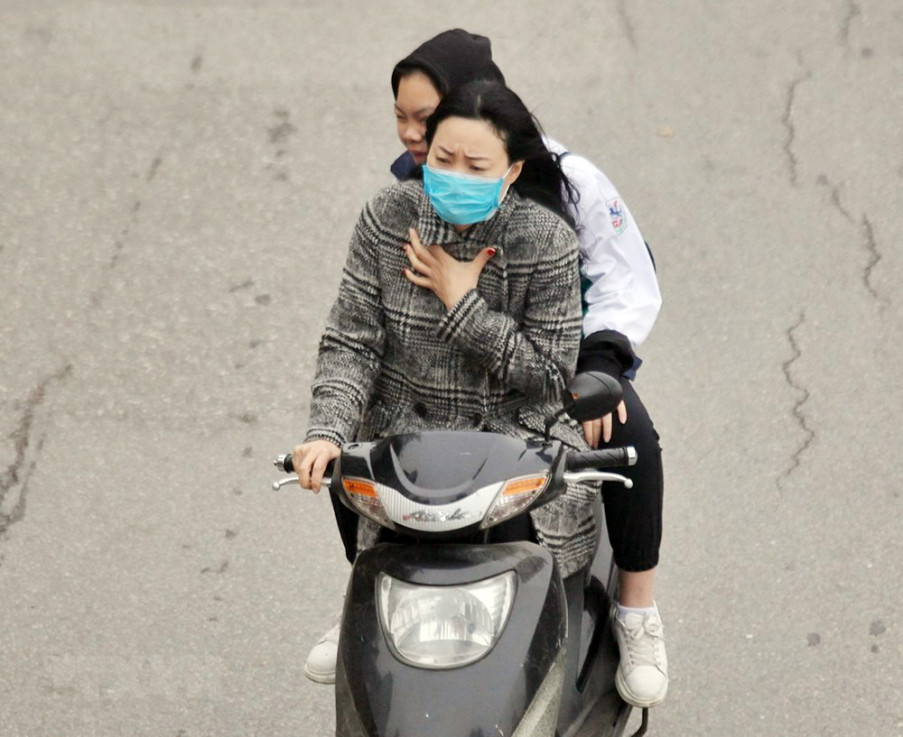 Người dân Thủ đô cảm nhận rõ cái lạnh khi lưu thông trên đường. Tuy nhiên, một số người không đội mũ bảo hiểm khi đi xe máy