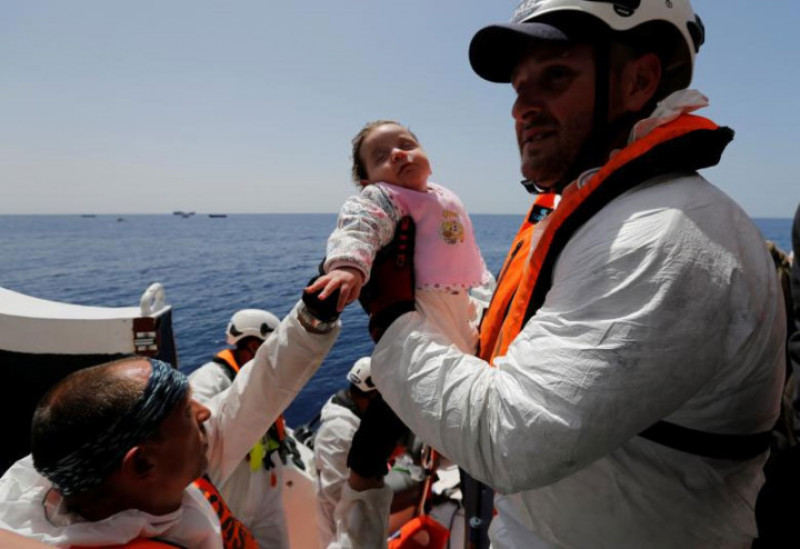 Một em bé di cư được đưa lên thuyền Phoenix trong một chiến dịch cứu hộ ở Địa Trung Hải, trong vùng biển quốc tế ngoài khơi bờ biển Libya.