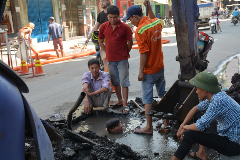 Một nhóm công nhân đang sửa hệ đường ống nước bị vỡ.