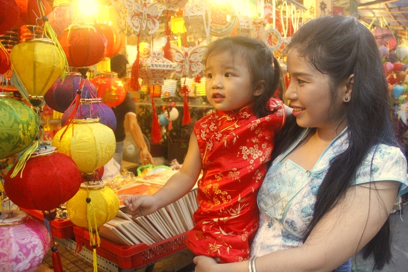 Chị Đỗ Thị Yến Trinh (Q.Tân Bình, TP.HCM) đang bế con gái Anh Thu, 3 tuổi. Chị Trinh cho biết, rất vui khi được cùng con dạo chơi trong không gian truyền thống vô cùng rực rỡ.