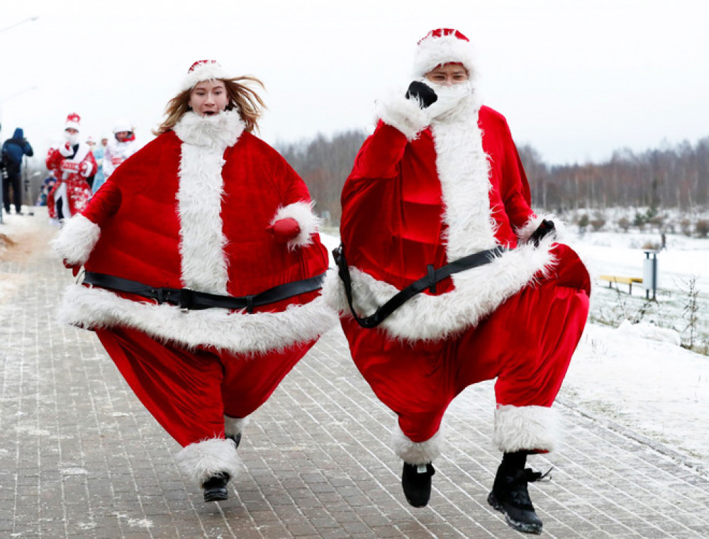 Cặp đôi mặc trang phục của Ông già Noel tham gia cuộc thi chạy Santa Run ở Minsk, Belarus. 

