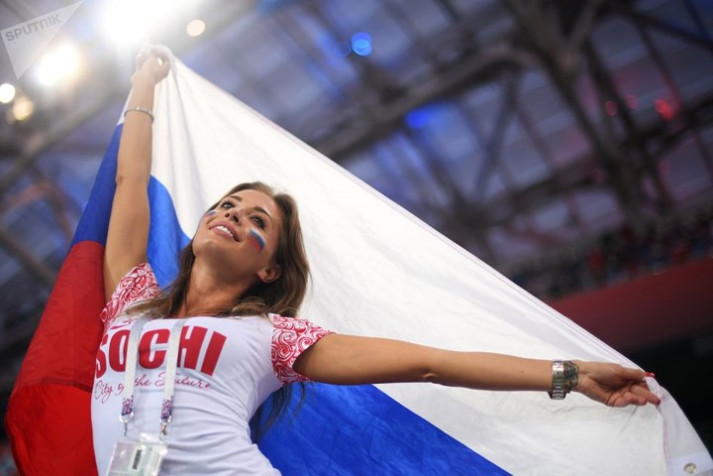 Cổ động viên đội Nga tạo dáng với lá quốc kỳ trên tay.