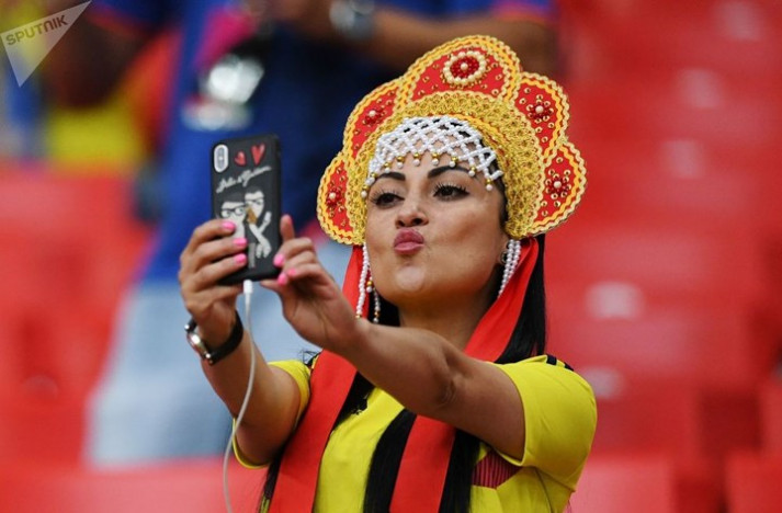 Nữ cổ động viên Colombia chụp ảnh selfie khi có mặt trên khái đài theo dõi trận Anh-Colombia.